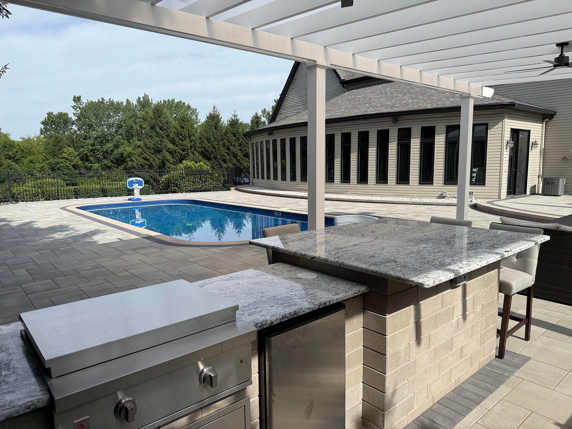 A white pergola with outdoor kitchen