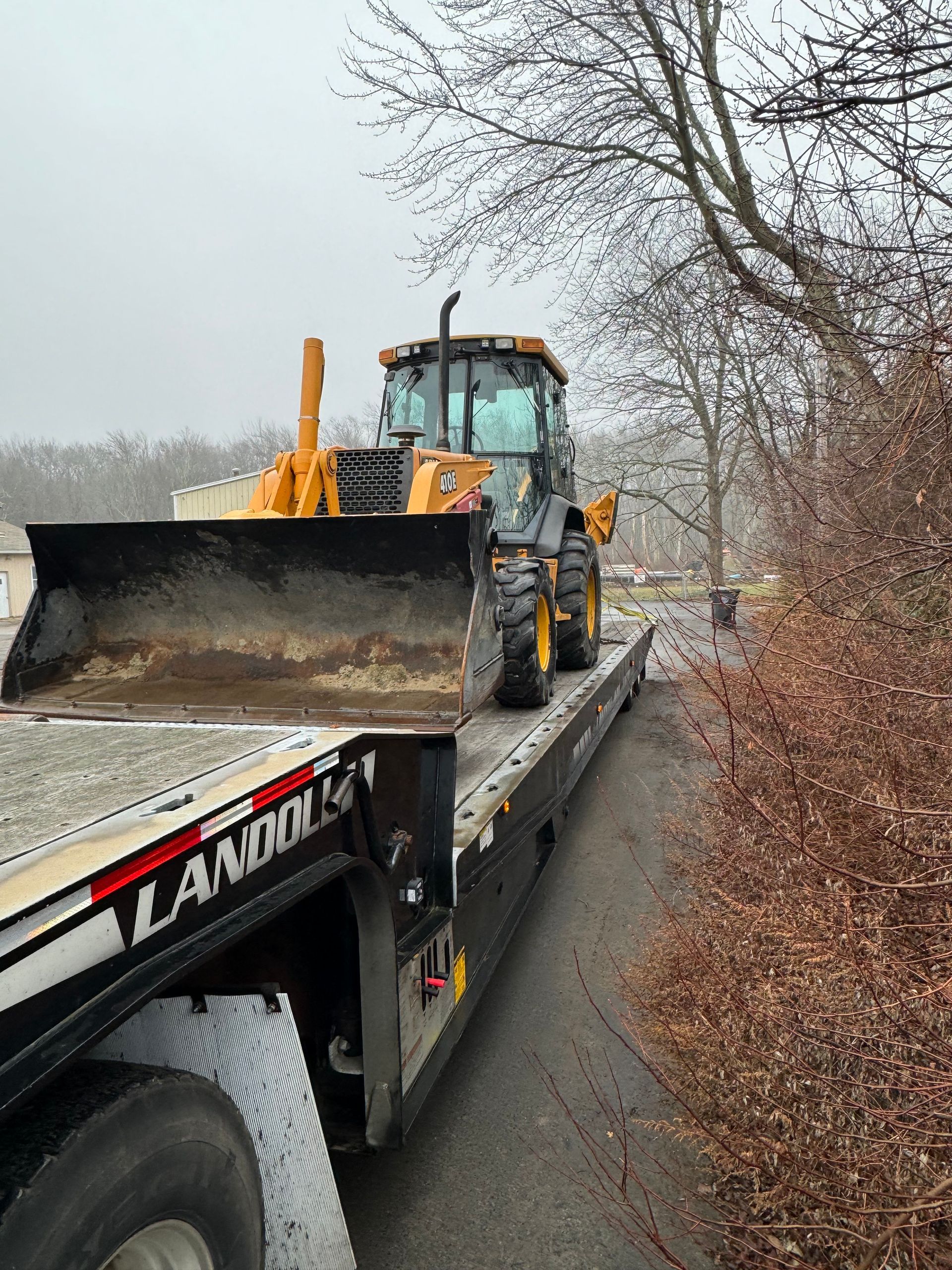 A bulldozer is sitting on top of a flatbed truck.