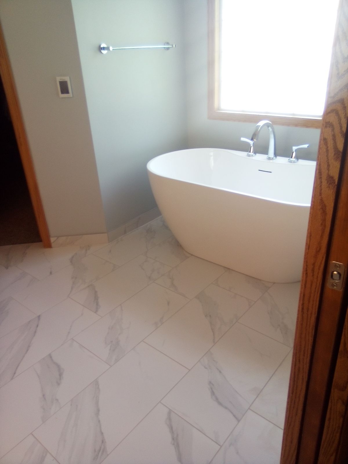 A bathroom with a bathtub and a window