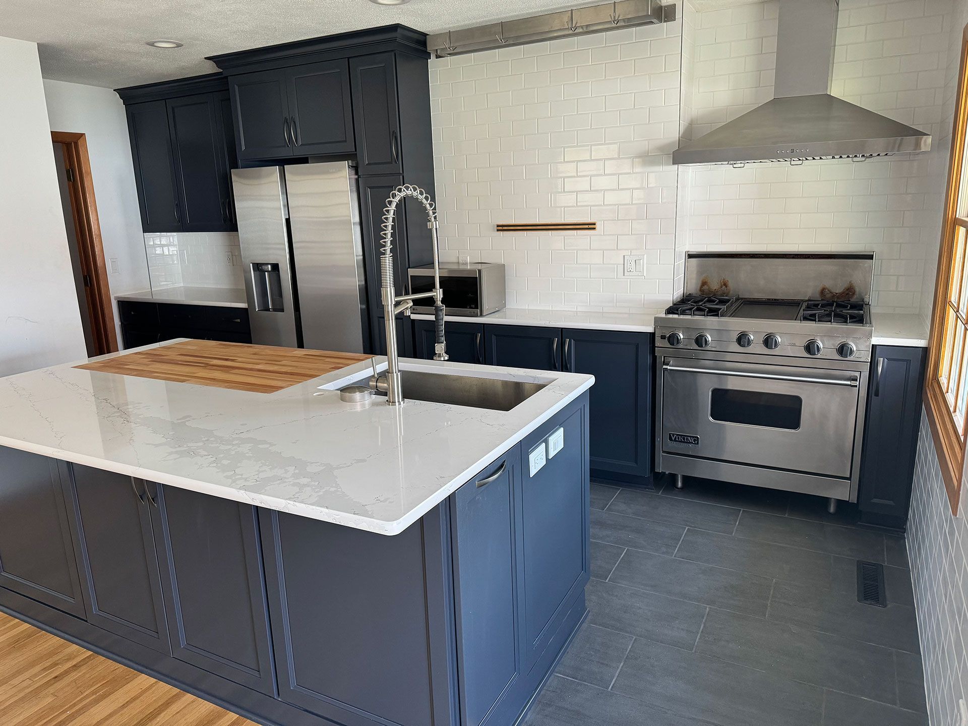 A kitchen with stainless steel appliances and a large island in the middle