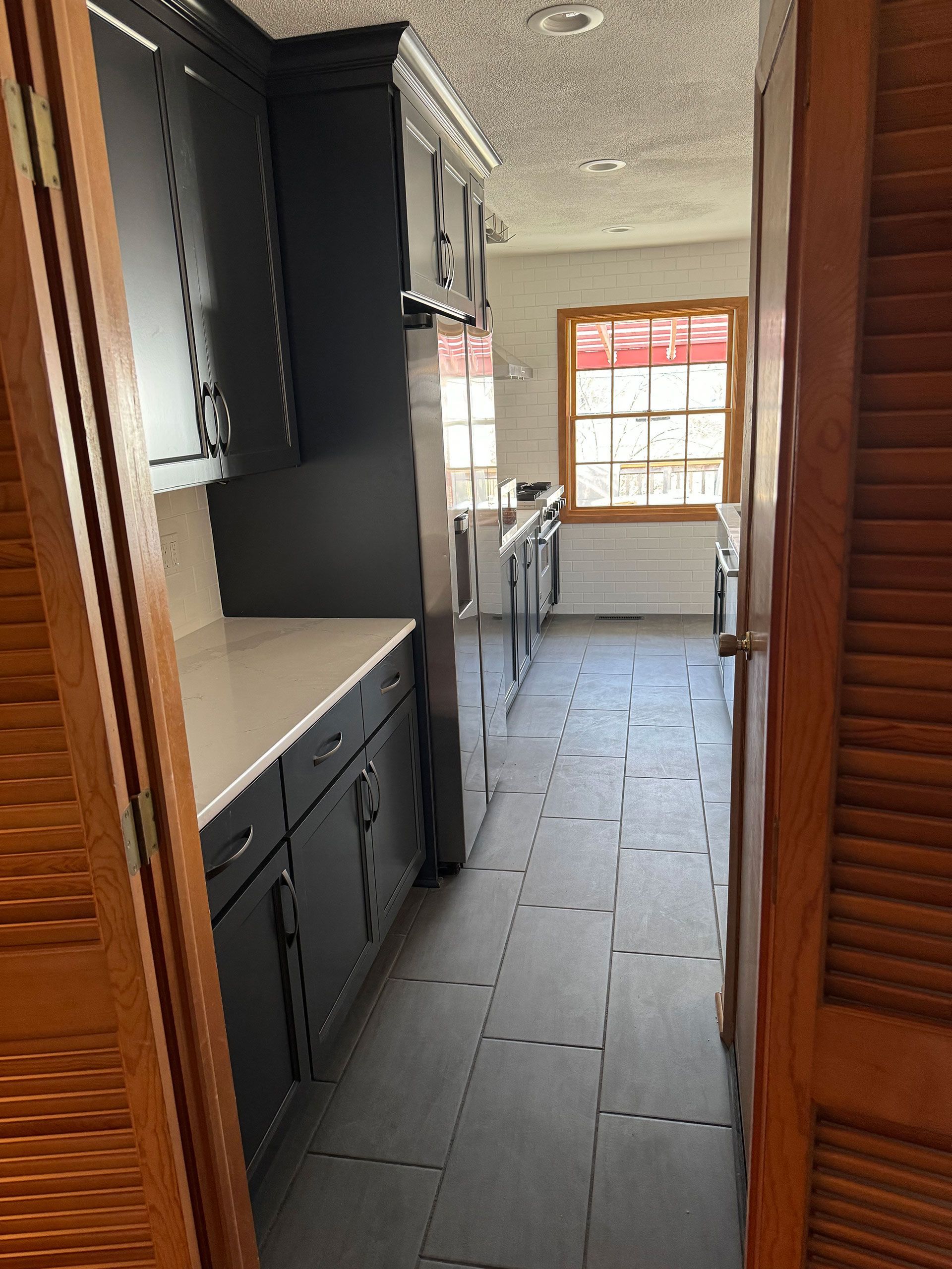 A kitchen with black cabinets and stainless steel appliances