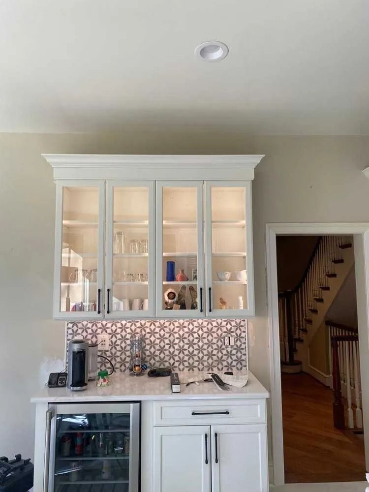 An electrician is working on an electrical panel with a multimeter.
