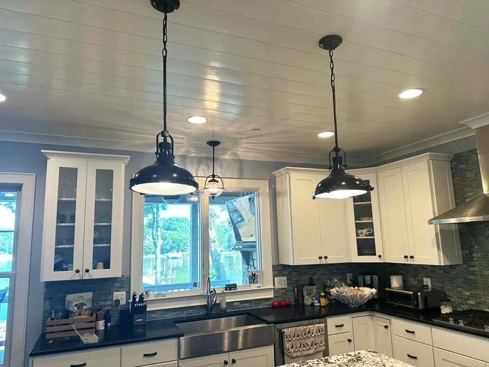 A man is holding two security cameras and a pair of pliers.