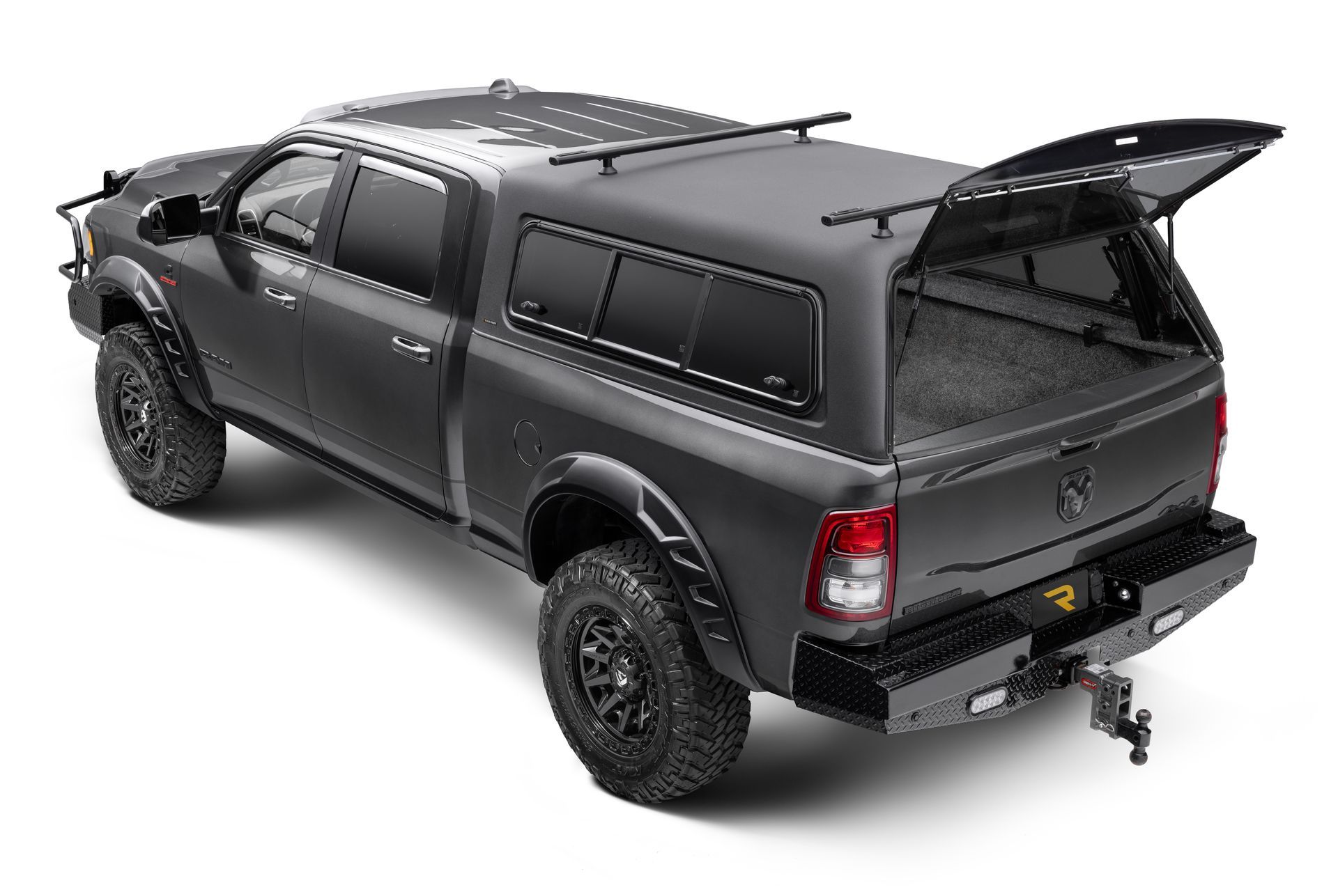 A matte black pickup truck with an open camper shell and roof rack, parked against a white background.