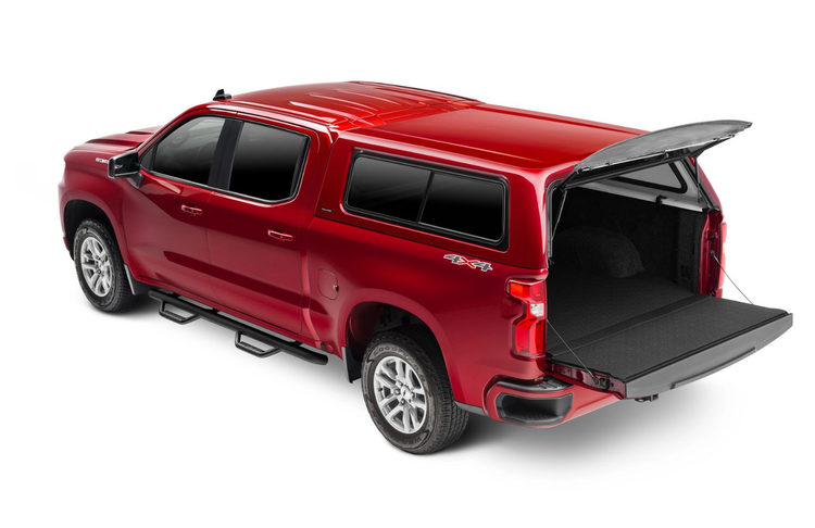 Red pickup truck with a matching camper shell, rear door open.