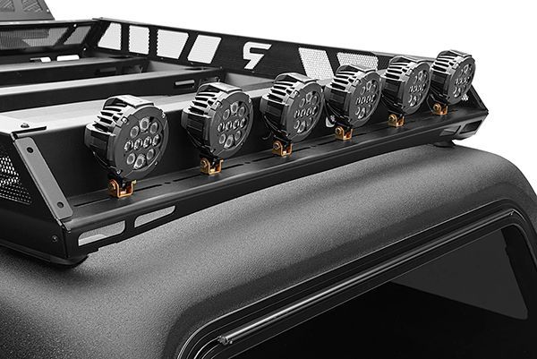 A black metal roof rack mounted on a vehicle, featuring a row of six circular LED off-road lights.