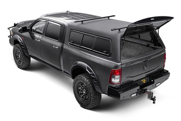 A matte gray pickup truck with an open camper shell and roof rack, parked against a white background.
