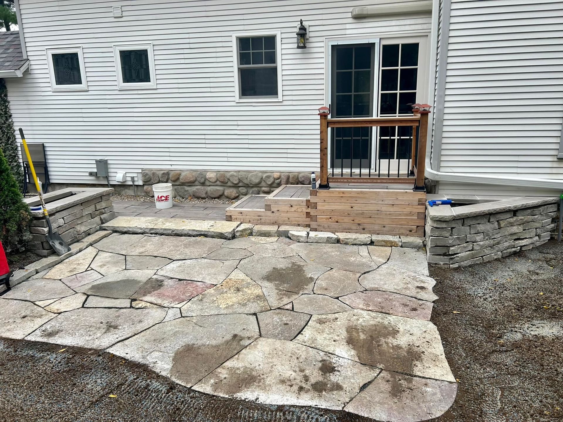 A long, newly poured concrete driveway leading to a house with two garage doors under an overcast sky.