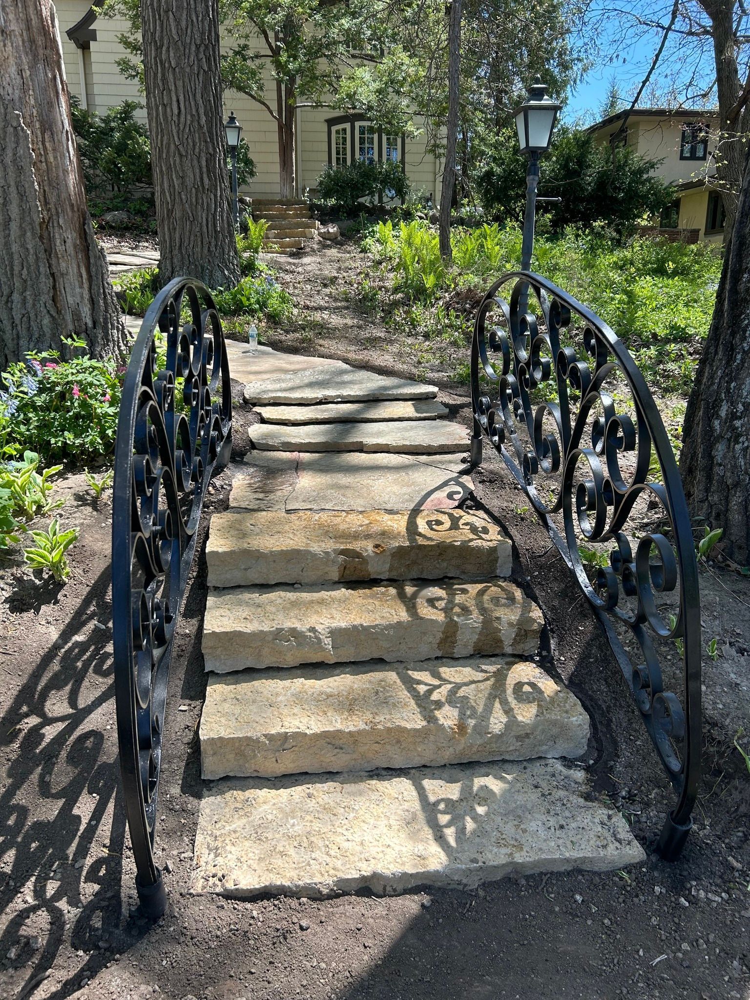 A stone wall with a white fence in the background.