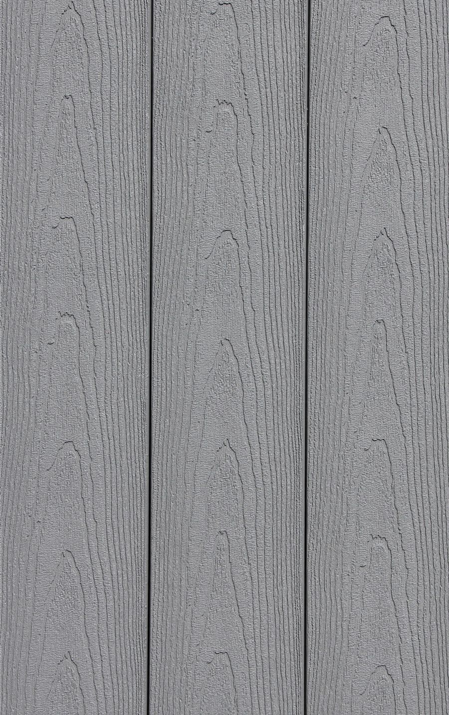 A close up of a gray wooden wall with a grainy texture.
