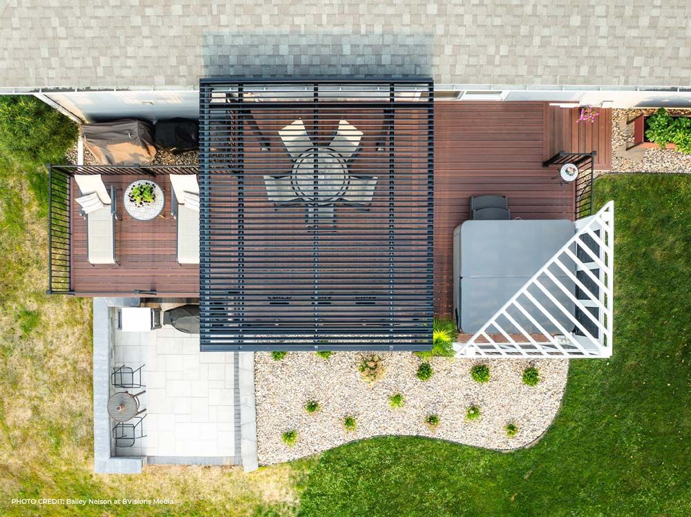 Overhead view of a backyard deck with dining area, hot tub, and lounge chairs.
