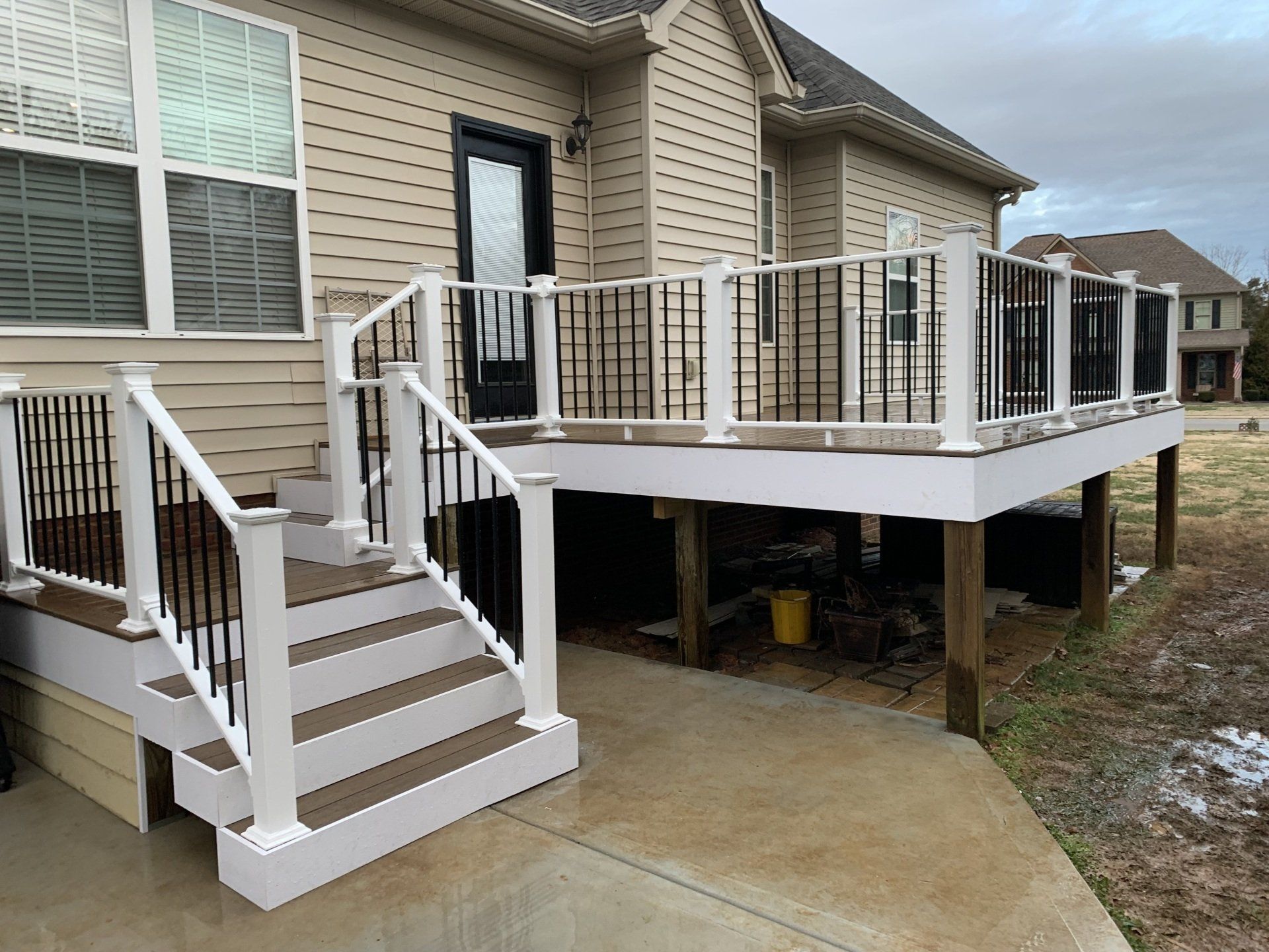 A house with a deck and stairs in front of it.