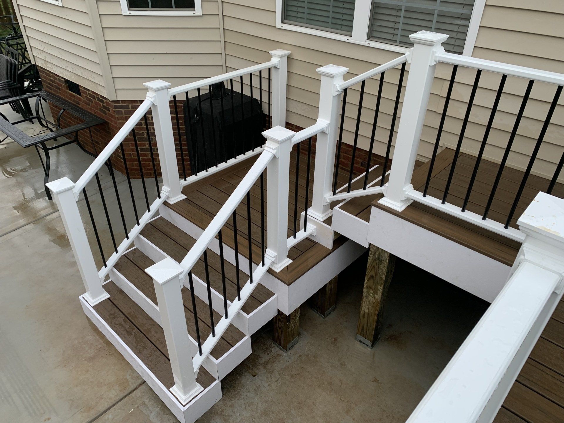 A wooden deck with stairs and a white railing
