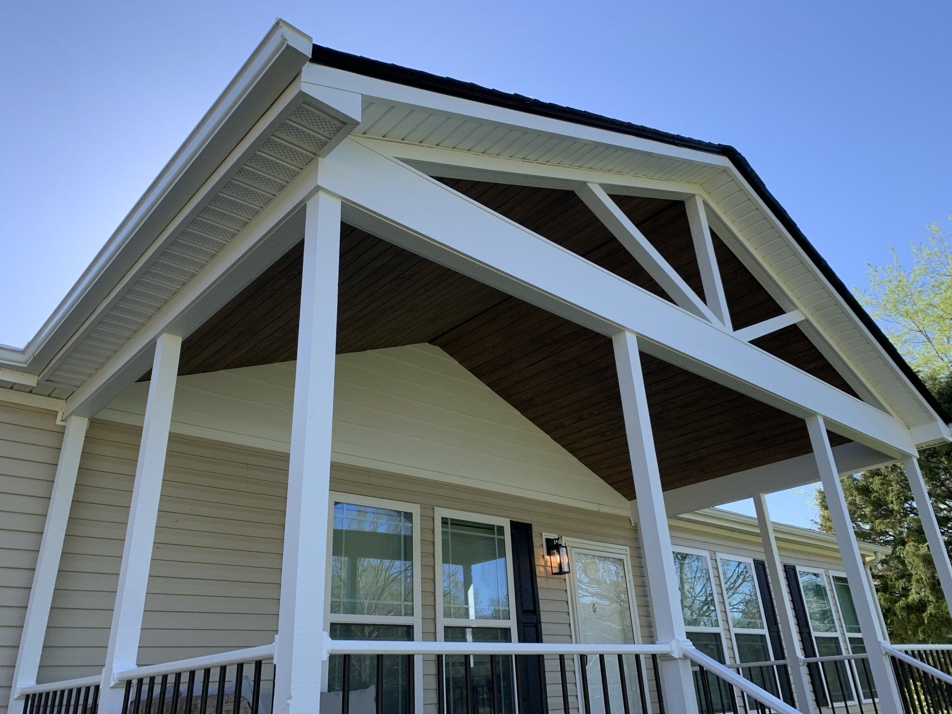 A house with a porch and a white roof