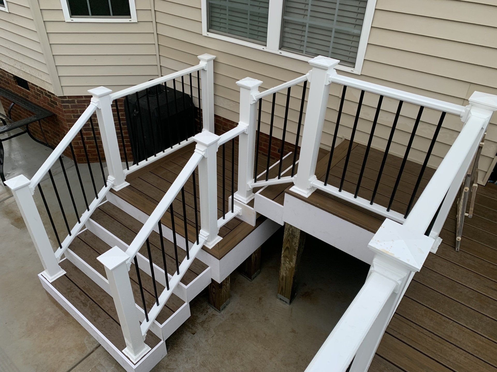 A wooden deck with stairs and a white railing
