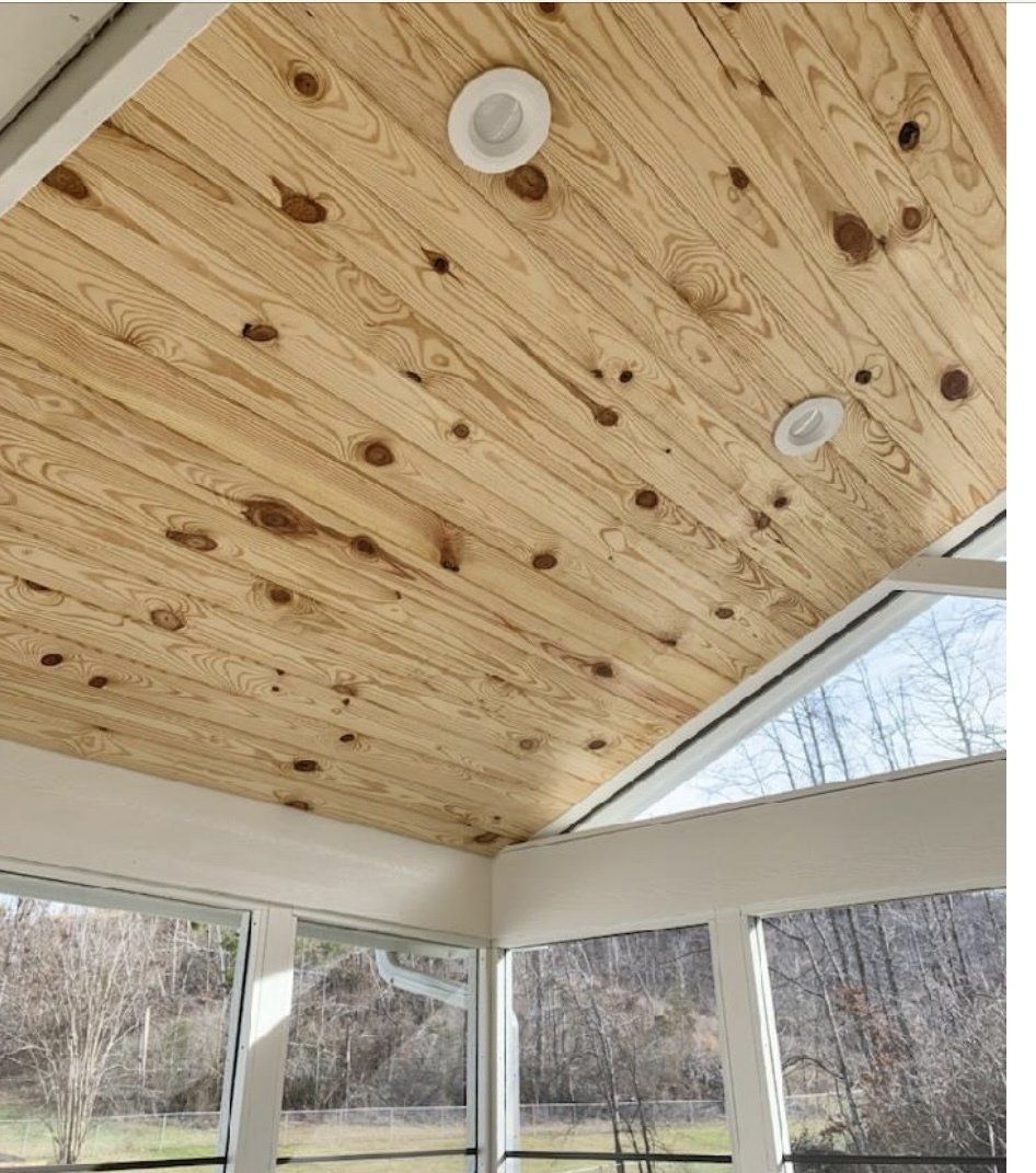 A room with a wooden ceiling and lots of windows