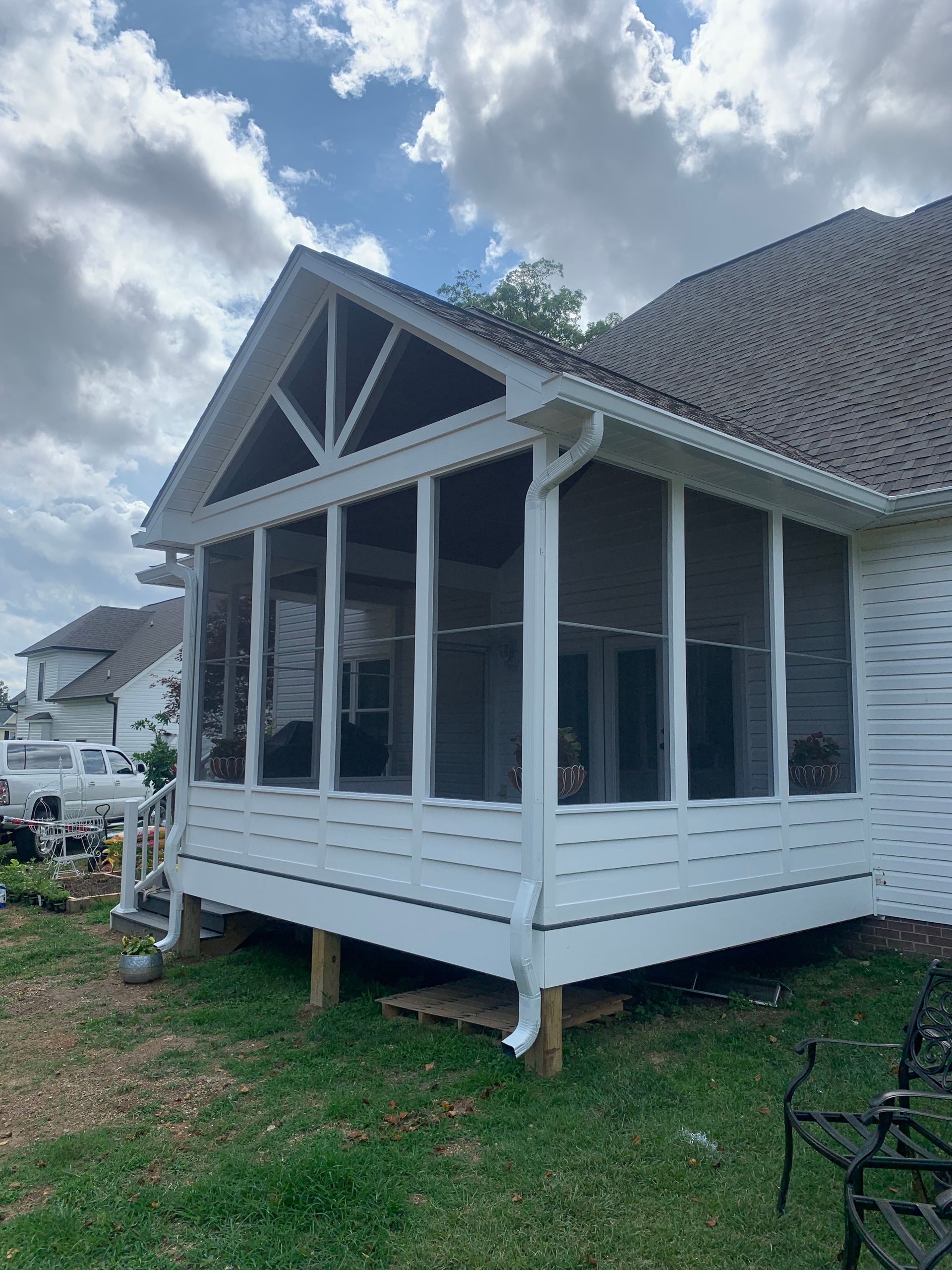 A screened in porch is being built on the side of a house.