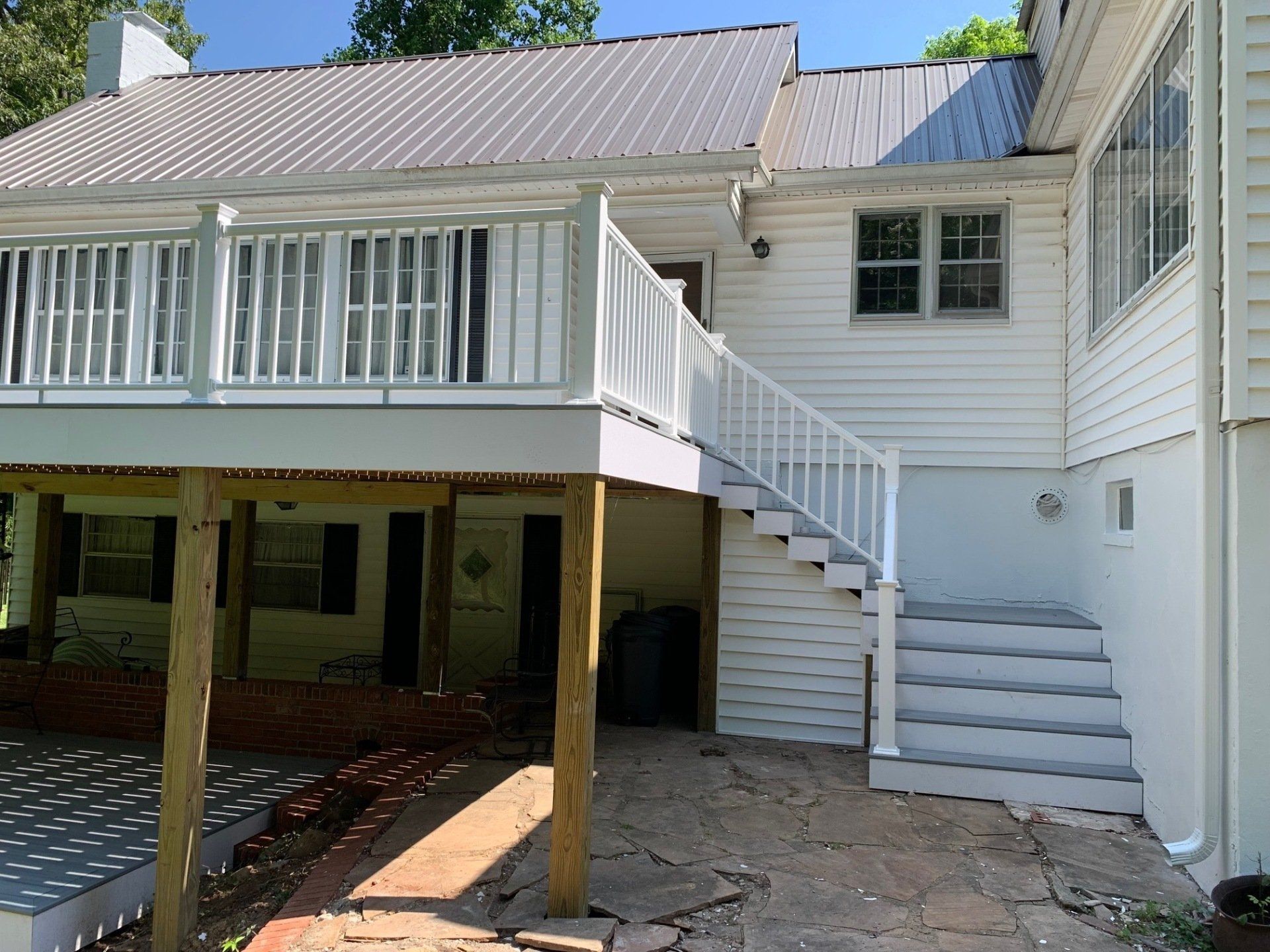 A white house with a white deck and stairs