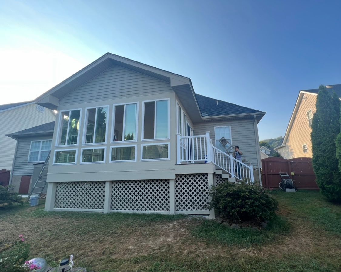 The back of a house with a lot of windows and a deck.