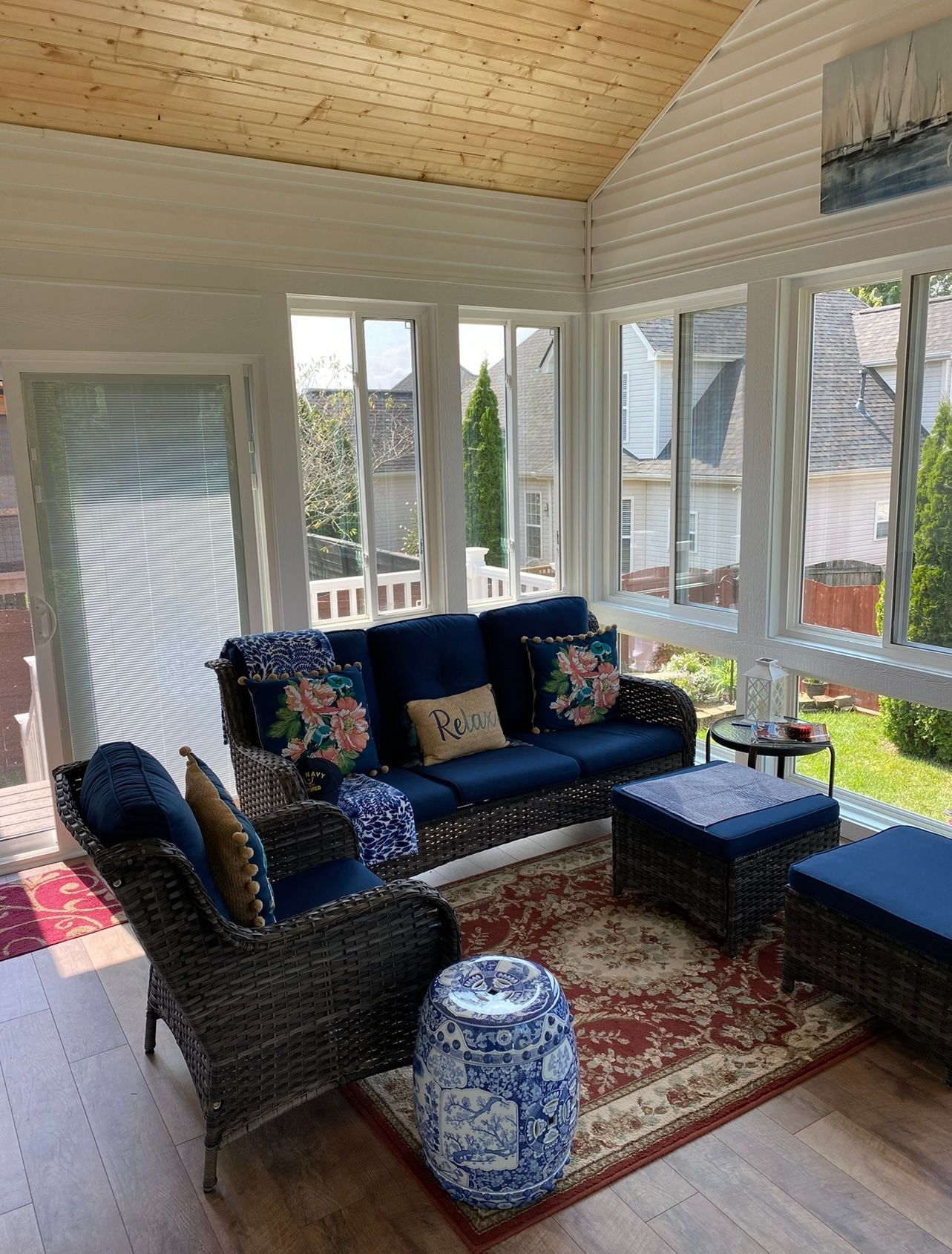 A living room with a couch , chairs , ottoman and rug.