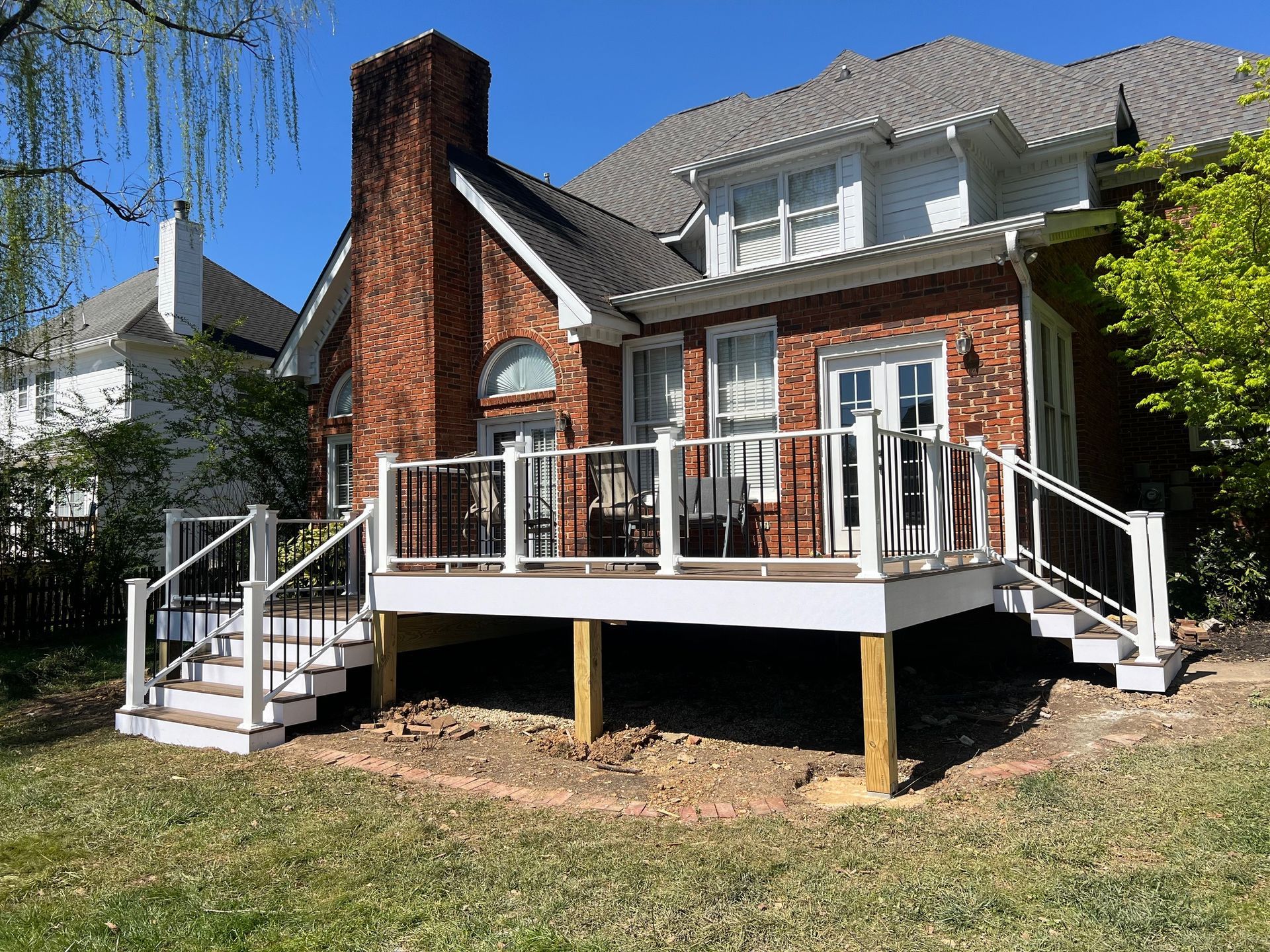 A large brick house with a large deck in front of it.