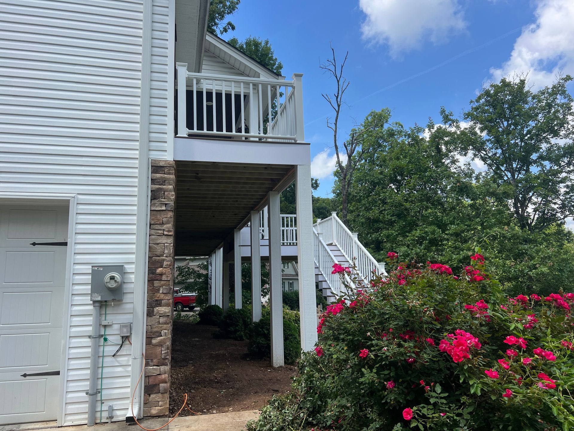 A white house with a covered porch and a balcony.