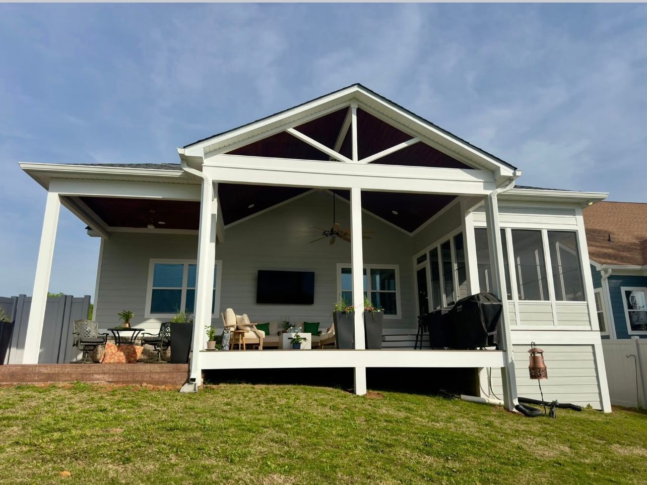 A white house with a screened in porch and a purple roof