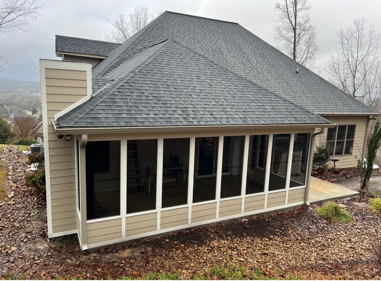 A house with a screened in porch on the side of it.