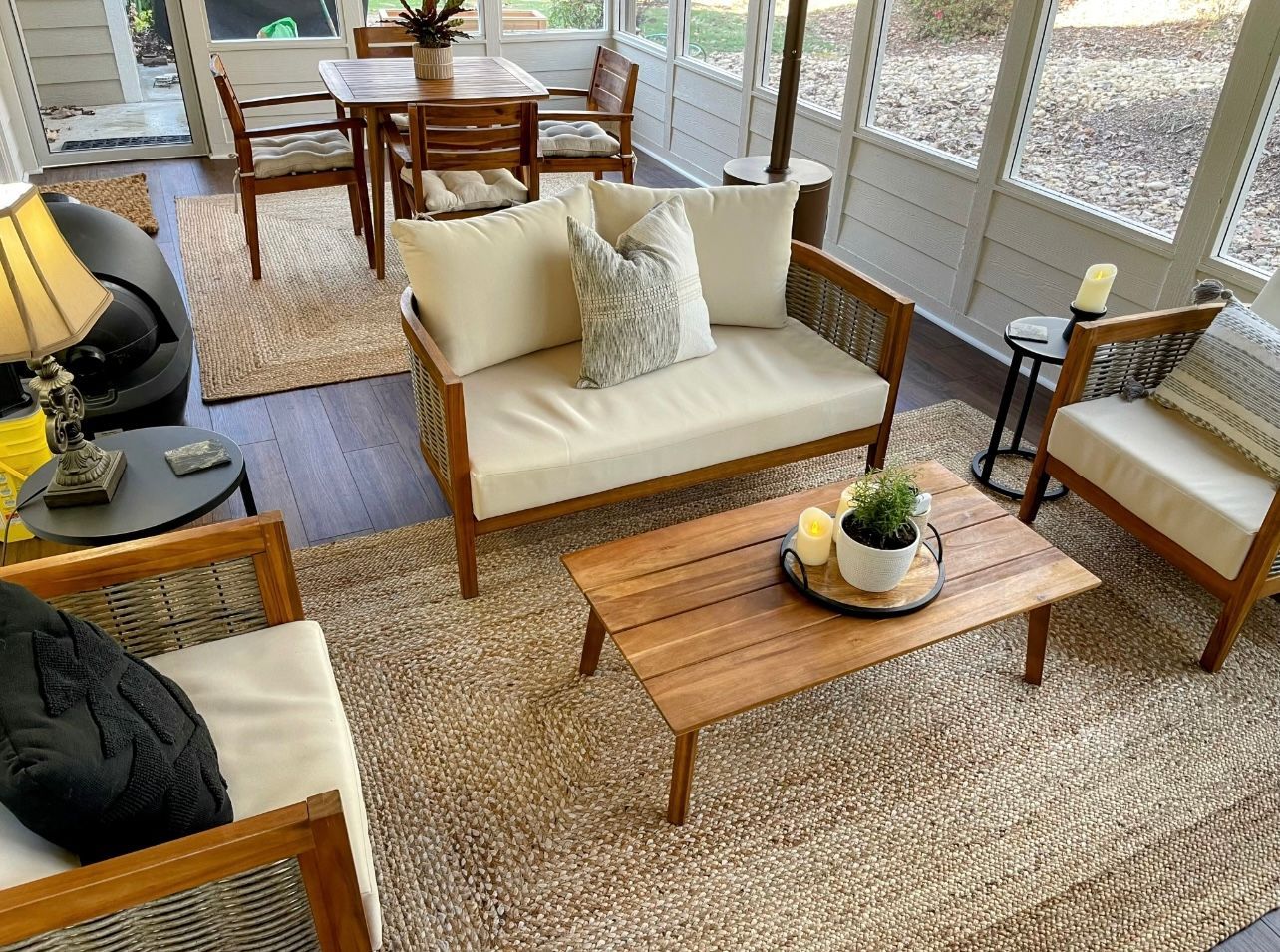 A living room with a couch , chairs , a table and a rug.