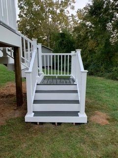 A white deck with black steps and a white railing.