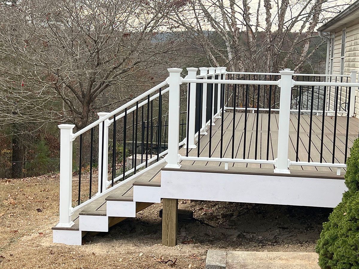 A deck with stairs and a white railing
