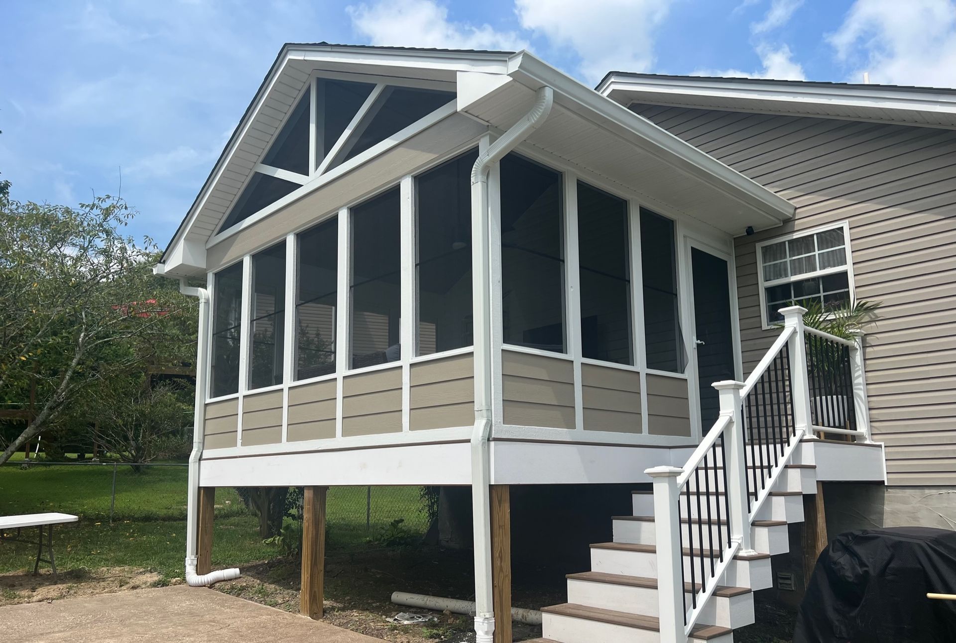 A screened in porch with stairs leading up to it.