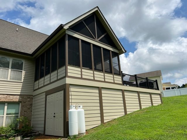 A screened in porch on the side of a house