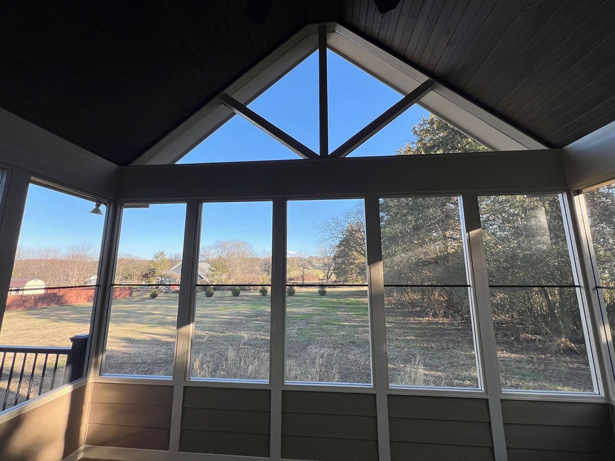 A screened porch with a lot of windows