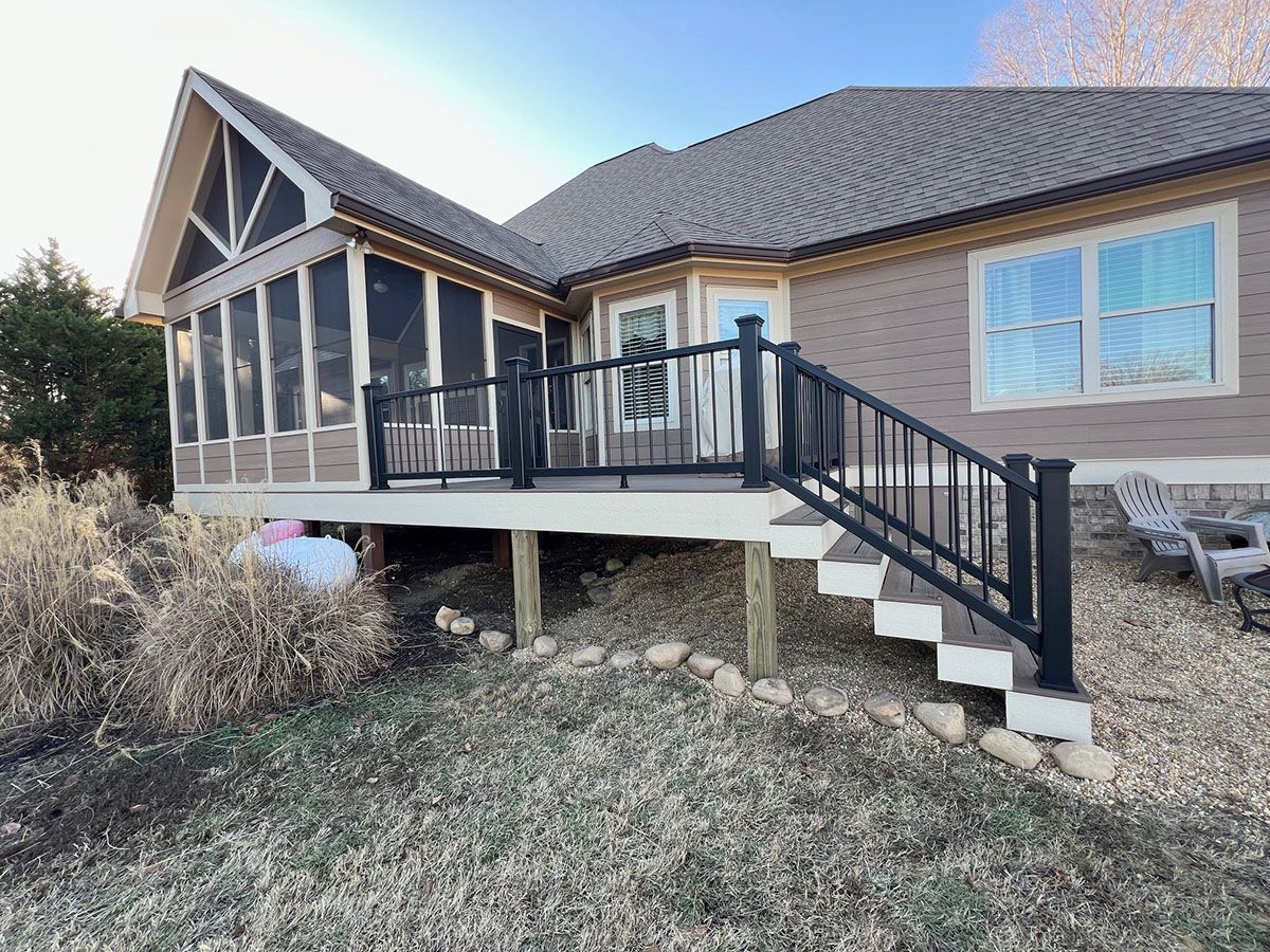 A house with a screened porch and a deck with stairs