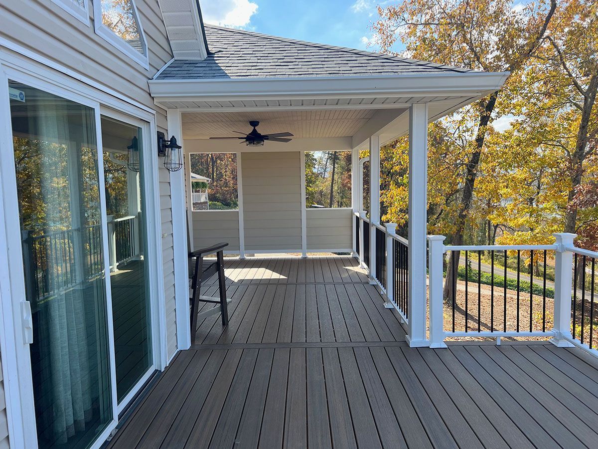 A large screened porch with a wooden deck