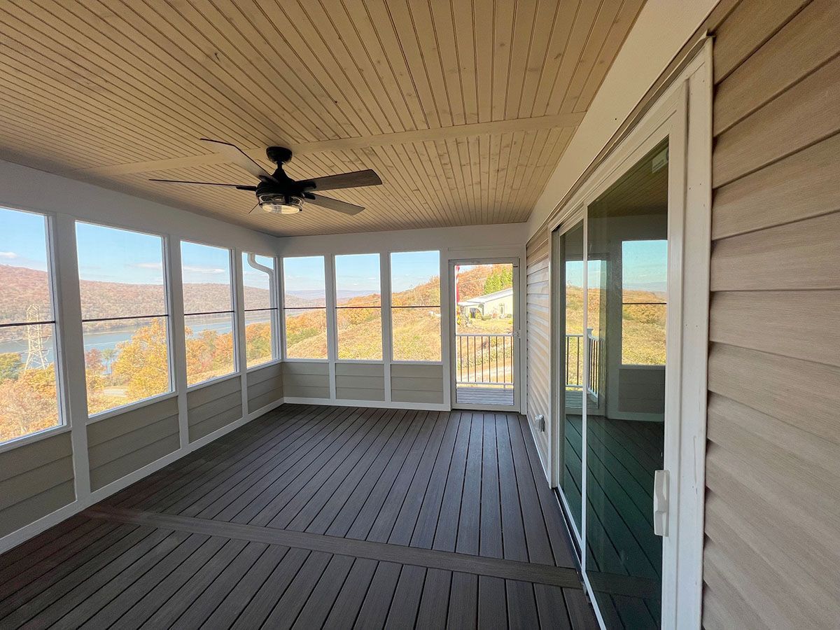 A spacious screened porch with a wooden deck