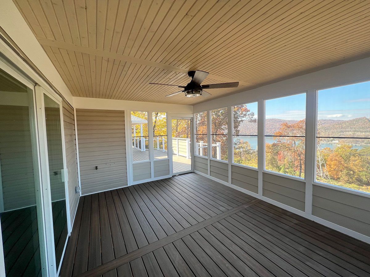 A beautiful screened porch with a wooden deck
