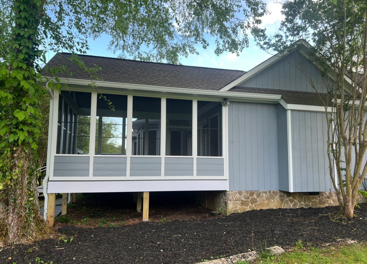 A house with a screened in porch on the side of it.