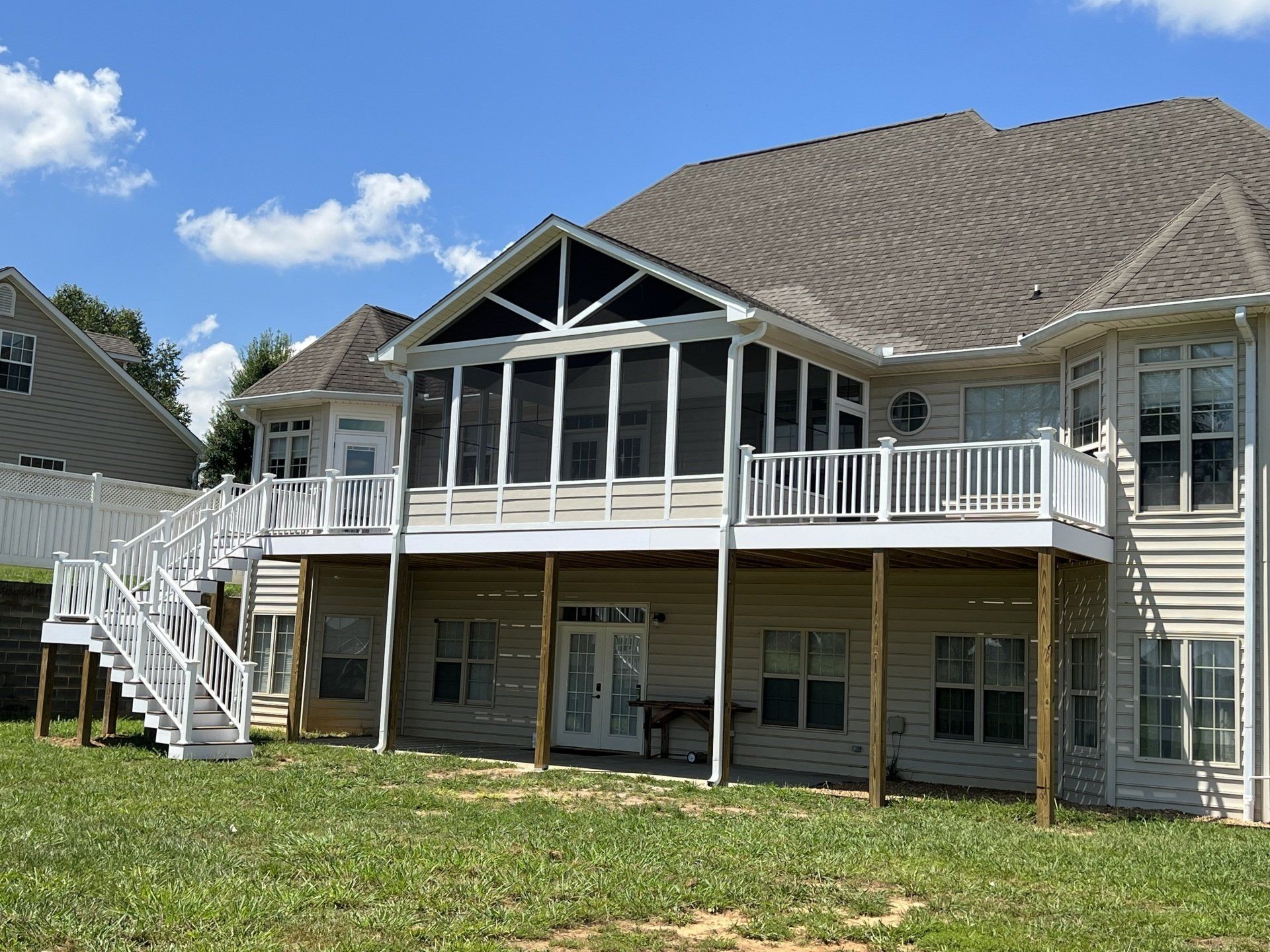 A large house with a screened in porch and stairs