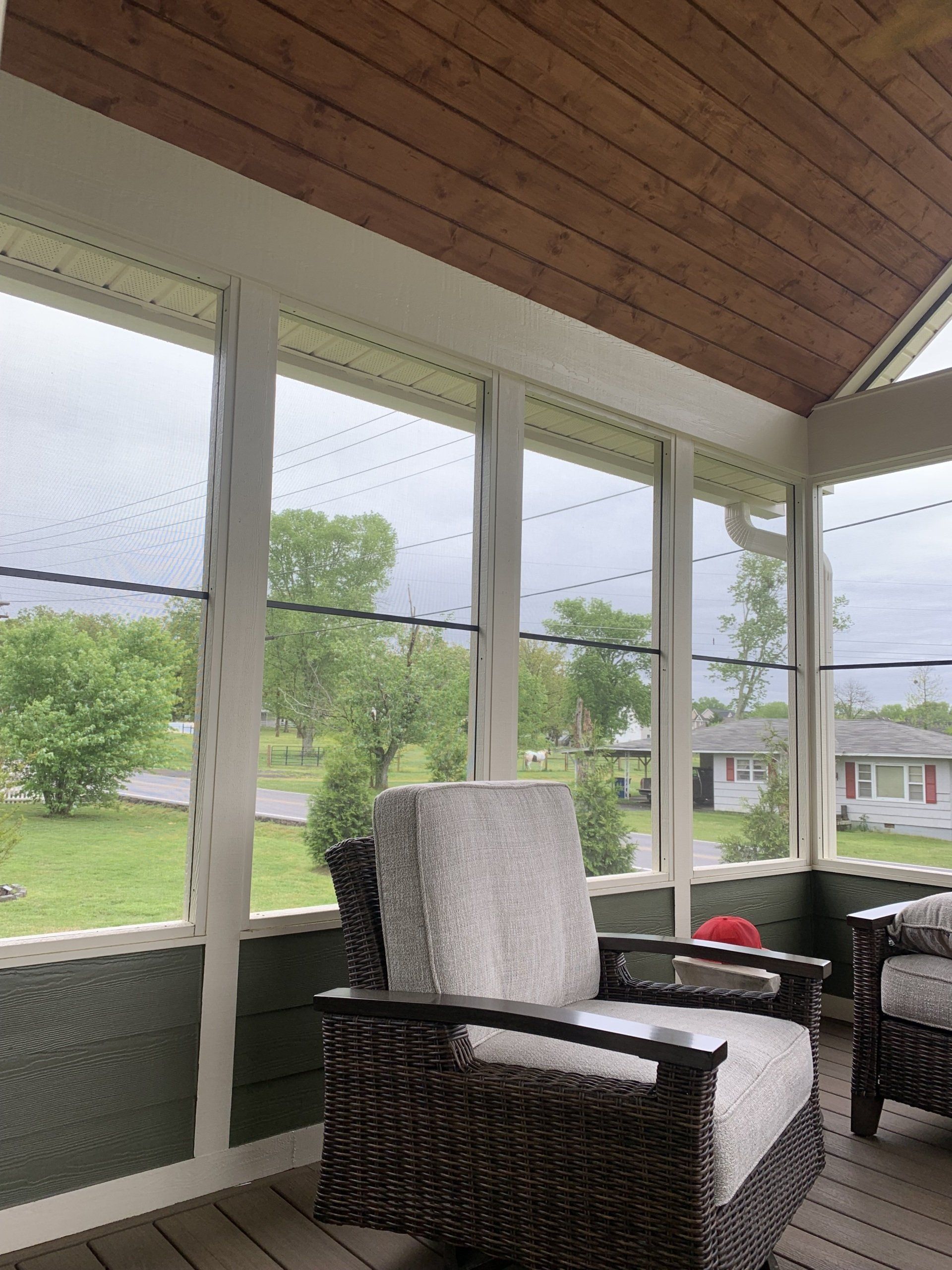 Screened room with gray sofa and outside view