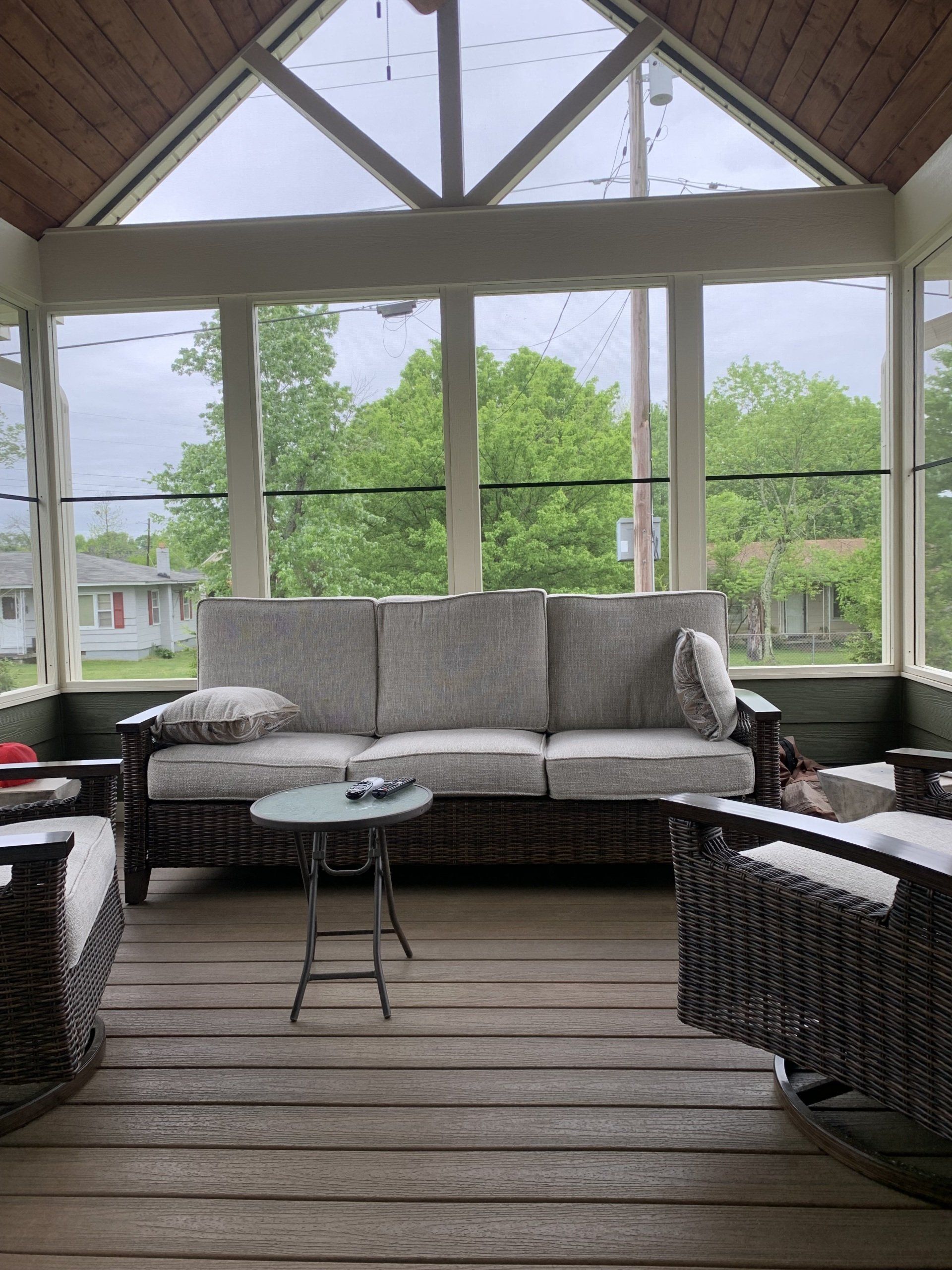 Screened porch with gray sofa and small round center table