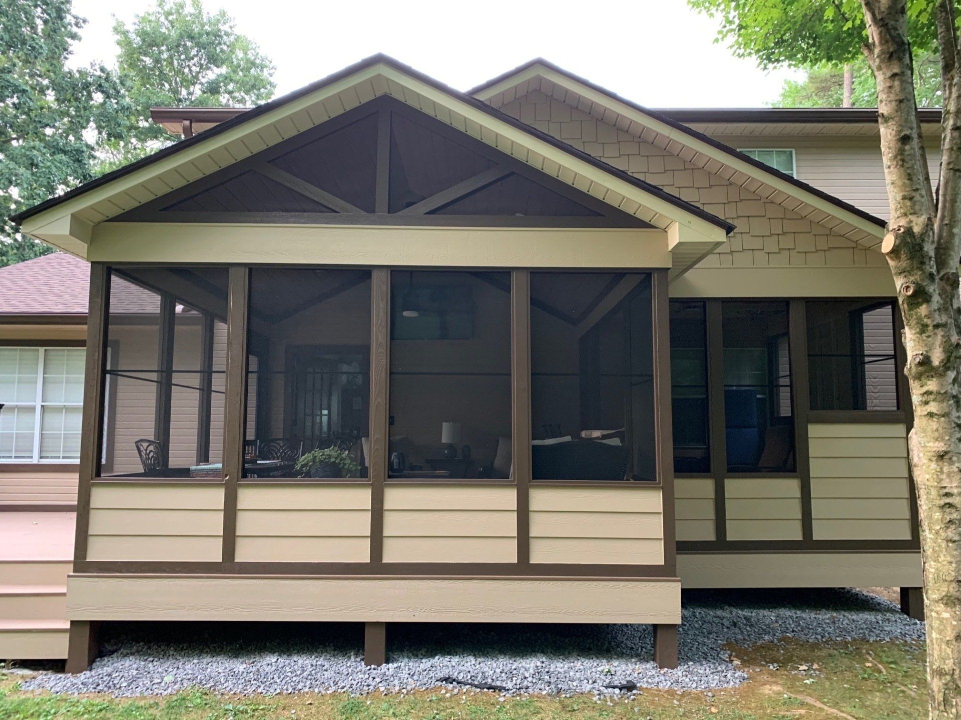 A screened in porch on the side of a house