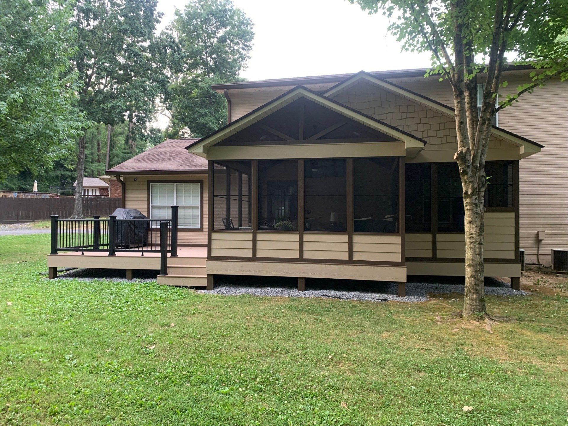A small house with a screened in porch and deck