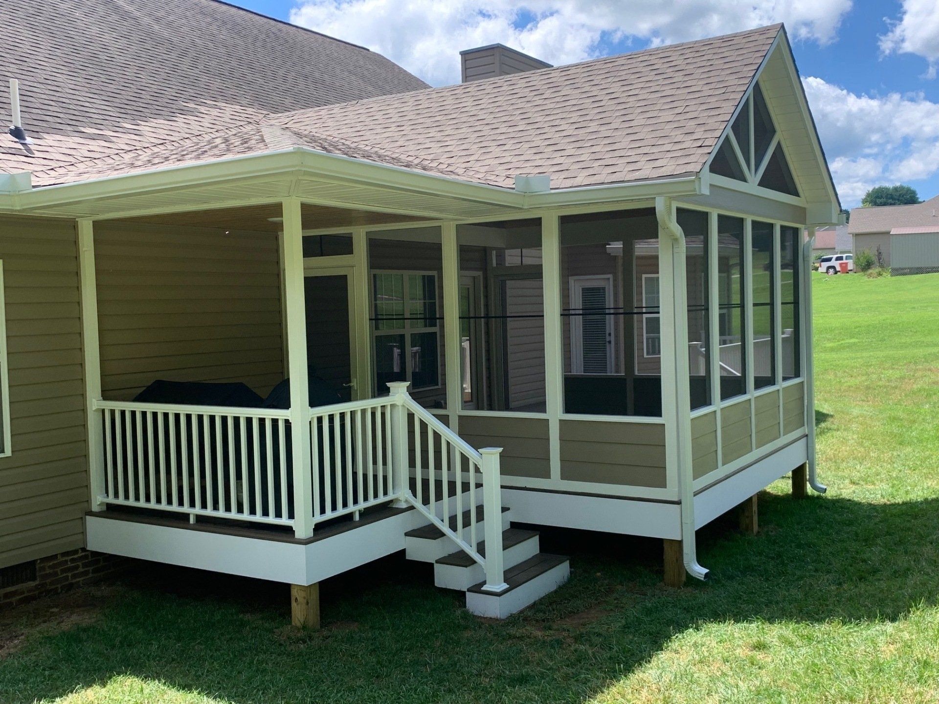 A screened in porch on the side of a house.