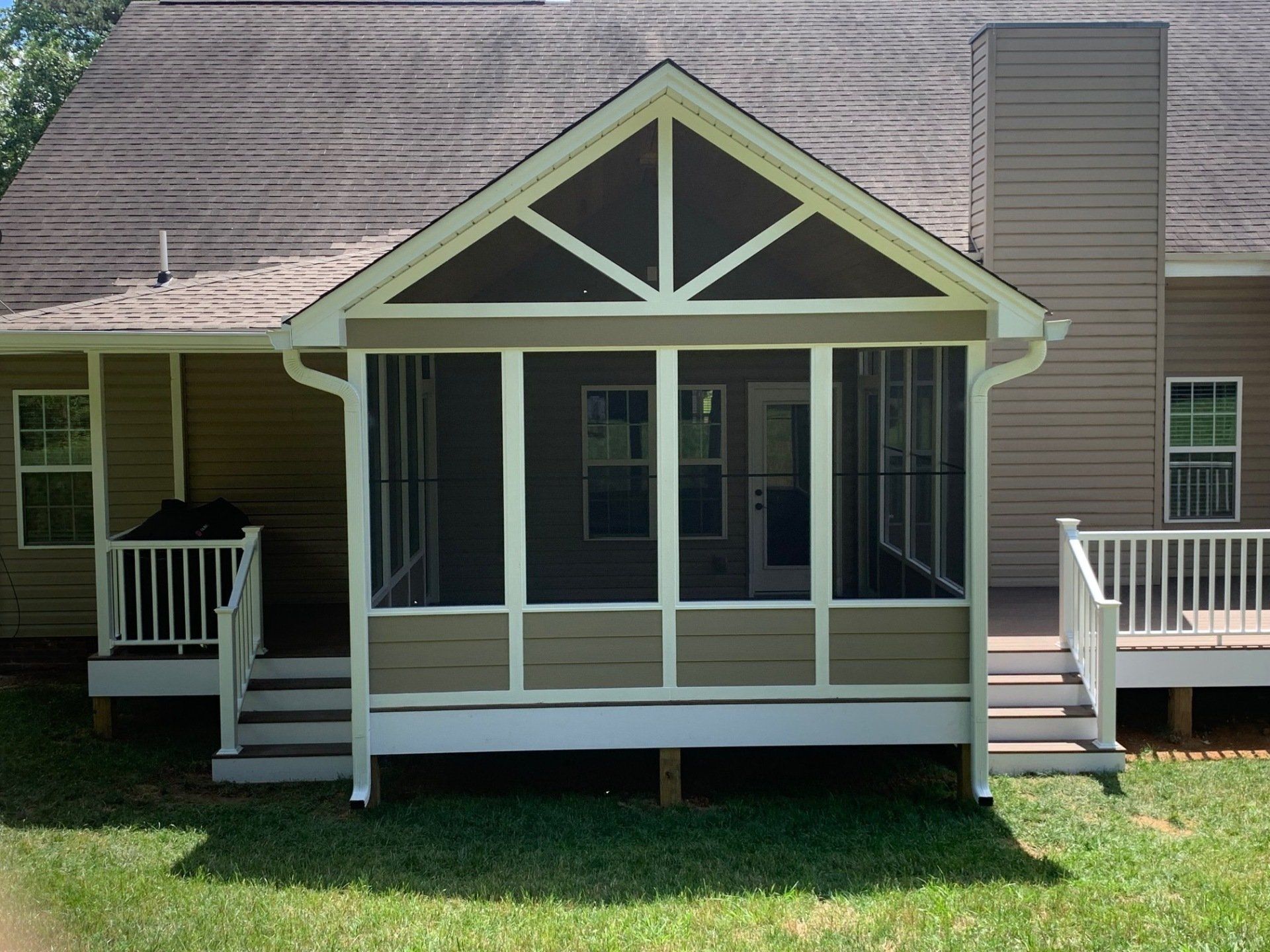 A screened in porch on the back of a house