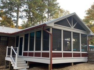A screened in porch on the side of a house