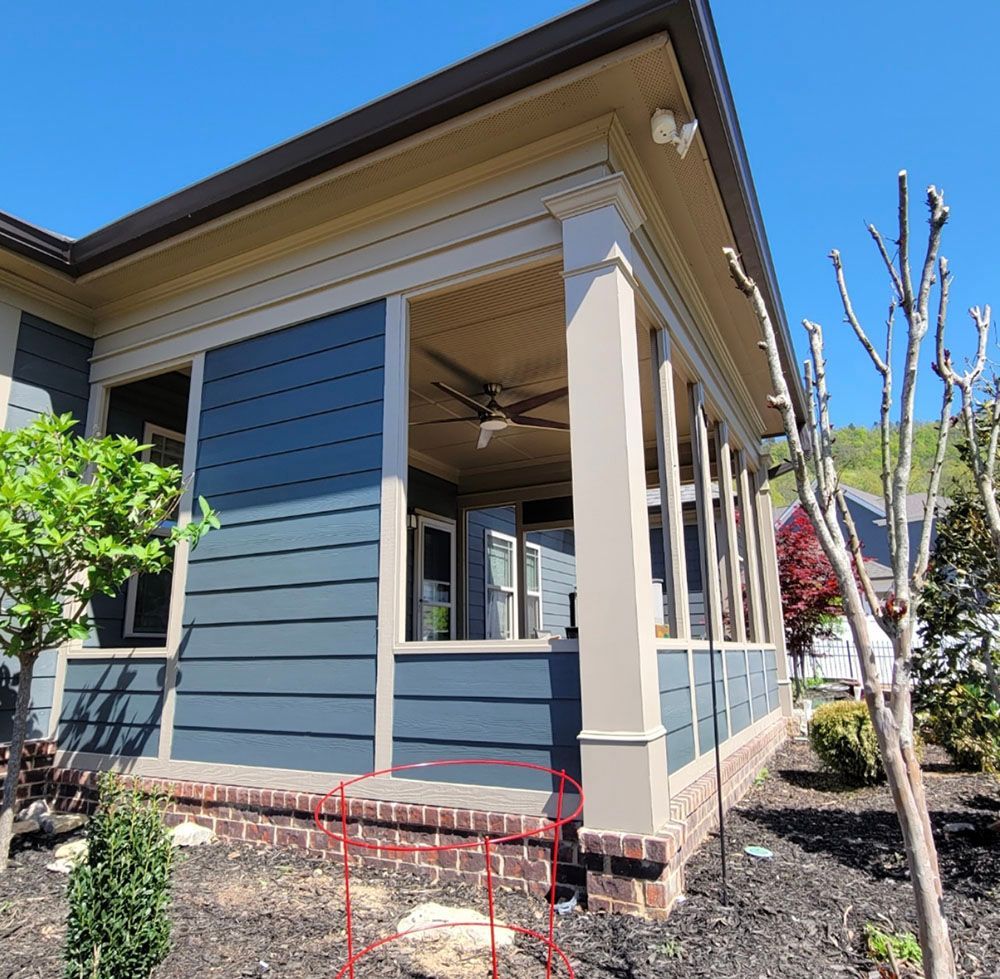 A blue house with a porch and a ceiling fan