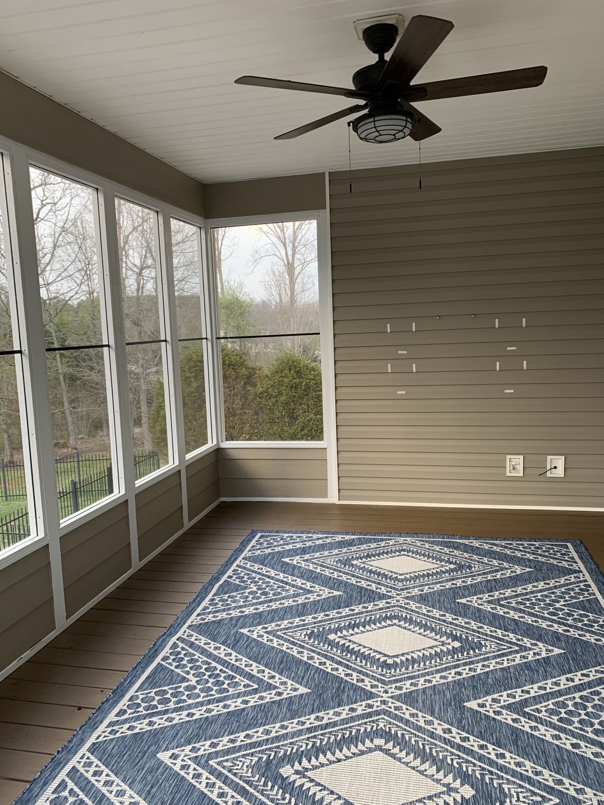 screened room with fan and carpet