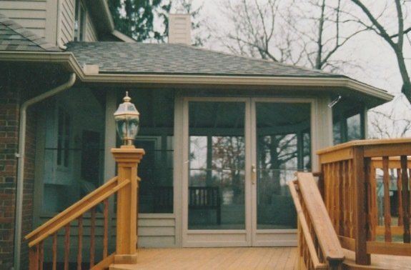 A house with a screened in porch with sliding glass doors